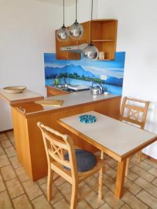 a kitchen with a table and chairs and a sink at Ferienwohnung EG mit Bergblick in Rimsting +9 photos