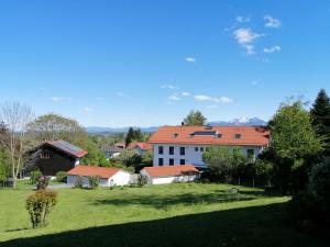 une maison avec un toit rouge dans un champ vert dans l'établissement Ferienwohnung EG mit Bergblick, à Rimsting