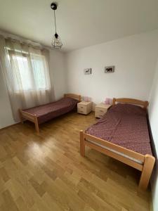 a bedroom with two beds and a wooden floor at Apartman Zlatija in Bajina Bašta