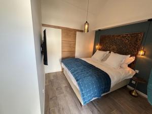 a bedroom with a large bed with a blue blanket at Le Domaine de Darvoy in Darvoy