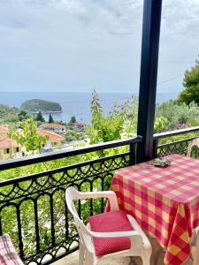 a table and chairs on a balcony with a view of the ocean at Betsanis Stafylos Apartments in Stafylos