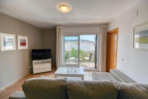 Una sala de estar con un sofá y una ventana grande. en Can Pep, en Calella de Palafrugell