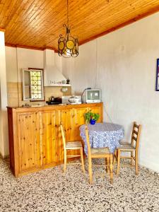 a dining room with a table and chairs and a kitchen at Betsanis Stafylos Apartments in Stafylos
