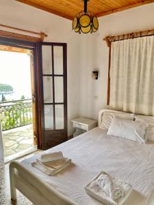 a bedroom with a white bed and a window at Betsanis Stafylos Apartments in Stafylos