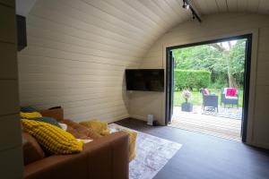 a living room with a couch and a sliding glass door at Foxes Den in South Cerney