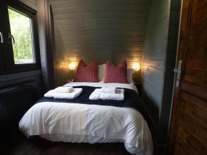 a bedroom with a large bed with towels on it at Foxes Den in South Cerney