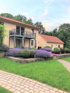 a house with a balcony and purple flowers at Ferienwohnung Am Hofjägerhaus in Gotha