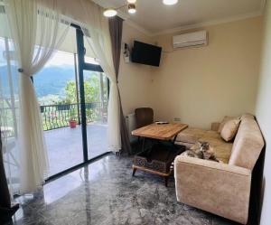 a living room with a couch and a table at 8 mountains Cottage near Chakvi in Gorgadzeebi
