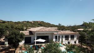 a large white house with a mountain in the background at VILLA ISULA by Intendance Excellency in Sainte-Lucie de Porto-Vecchio