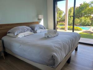 a large bed with two stuffed animals on it at VILLA ISULA by Intendance Excellency in Sainte-Lucie de Porto-Vecchio +30 photos