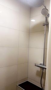 y baño con ducha y paredes de azulejos blancos. en Beethoven City, en Bonn