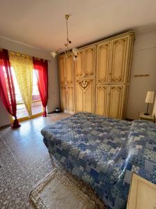 1 dormitorio con cama, armarios de madera y ventana en Ladispoli Seahouse, en Ladispoli