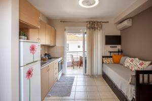 a kitchen and a living room with a couch and a refrigerator at Cute apartment 20m from beach in Nea Potidaea