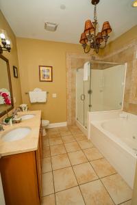 a bathroom with a tub and a sink and a shower at Water's Edge Inn - Adults Only in Folly Beach +13 photos