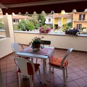 un tavolo e sedie su un balcone con vista su un edificio di La casa di Mamma, Appartamento di charme nel borgo a Luogosanto