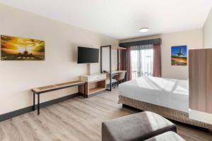 a hotel room with a bed and a desk at Best Western Plus Atlanta Airport East in Atlanta