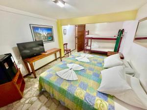 a room with a bed with a television and a bed sidx sidx sidx at Hostel e Pousada Barra da Tijuca in Rio de Janeiro