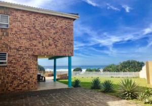 ポート・エドワードにあるSycamore Beach Houseの海の見えるレンガ造りの建物