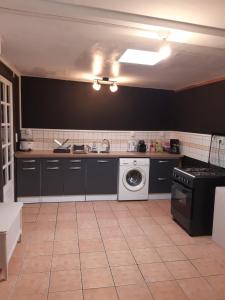 a kitchen with a sink and a washing machine at Le Zarlor à Cilaos in Cilaos +5 photos