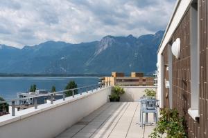 a balcony with a chair and a view of the water at Montreux Four Bedroom Penthouse by Swiss Hotel Apartments in Montreux