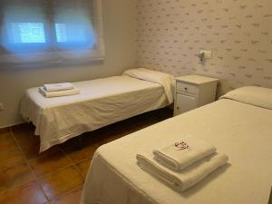 Una habitación con dos camas con toallas. en Casa en Ruta de la Plata con piscina comunitaria, en Guillena 9 fotos más