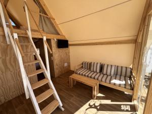 a living room with a couch and a ladder at Tamarit Beach Resort in Tamarit