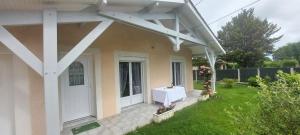 - une terrasse couverte à l'avant d'une maison avec une porte blanche dans l'établissement Maison Solyne Andernos les Bains, à Andernos-les-Bains
