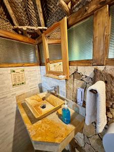 a bathroom with a sink and a stone wall at Eco Hostal Yuluka in El Zaino