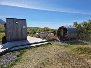 Una terraza de madera con una casa de hobbit en un campo. en Hotel Hafnarfjall, en Borgarnes
