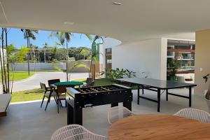 ein Wohnzimmer mit einem Grill, einem Tisch und Stühlen in der Unterkunft Makia Beach Experience in Ipojuca