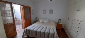 une chambre avec un lit avec des draps blancs et une fenêtre dans l'établissement Departamento céntrico en San Martín, amplio, con aire acondicionado y cochera privada, à San Martín