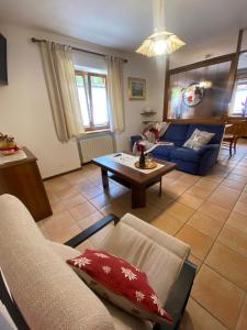 a living room with a blue couch and a table at Appartamento Madama in Falcade