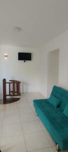 uma sala de estar com um sofá verde e uma mesa em Cobertura Duplex com 3 Quartos na Praia dos Milionários Ilhéus - Ba - Mar Bello em Ilhéus