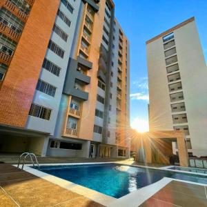a hotel with a swimming pool in front of two tall buildings at Apartamento Ejecutivo Valencia Excelente Ubicación in Valencia +5 photos