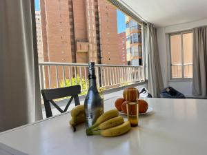 a bottle of champagne and bananas on a counter with a window at Lovely apartment Esperanto in Benidorm