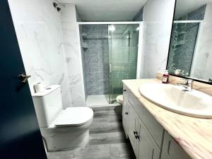 a bathroom with a toilet and a sink and a shower at Lovely apartment Esperanto in Benidorm +7 photos