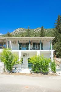 a white house with a mountain in the background at Billy's Luxury Apartment in Vlikhón