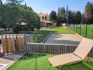 a chair sitting on a lawn next to a fence at gites du mas Donat in Perpignan