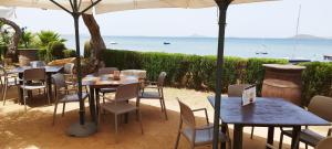 a restaurant with tables and chairs and the ocean at Alojamiento vacacional Calblanque junto Cabo de Palos in Playa Honda