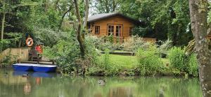 a wooden cabin on the side of a river at Beautiful 1-Bed Cabin in Newmarket in Newmarket