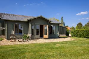 a green house with a porch and a lawn at Little Park Farm Queen Anne Farmhouse & Apartments in Stratfield Mortimer