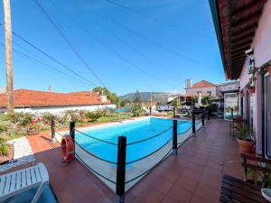 a swimming pool with a hammock next to a house at Sossego da Laurinda in Vila Praia de Âncora
