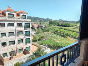 a balcony with a view of a building and a field at Edificio Fonte de Ons con piscina in Noalla