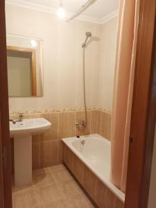 a bathroom with a sink and a tub and a mirror at Edificio Fonte de Ons con piscina in Noalla +10 photos