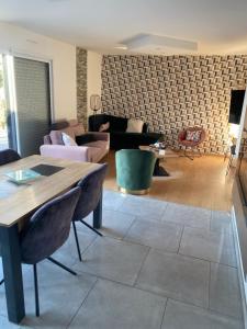 a living room with a couch and a table at Chambre mer in Orgères +5 photos