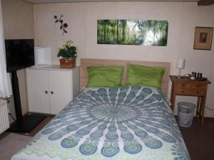 a bedroom with a bed with a blue and green comforter at Ferienwohnung Heustüble in Hinterzarten