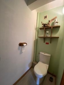 a bathroom with a toilet and a shelf on the wall at La faucille in Praranger +5 photos