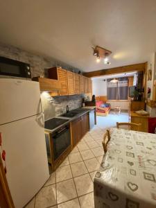 a kitchen with a white refrigerator and a table with at La faucille in Praranger