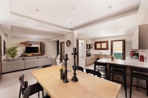 una cucina e un soggiorno con tavolo in legno di Villa Elena Corfu in Doukades a Doukádes