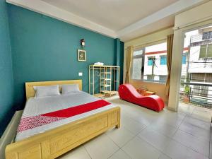 una camera da letto con un letto e una sedia rossa di Gold's House a Da Thanh